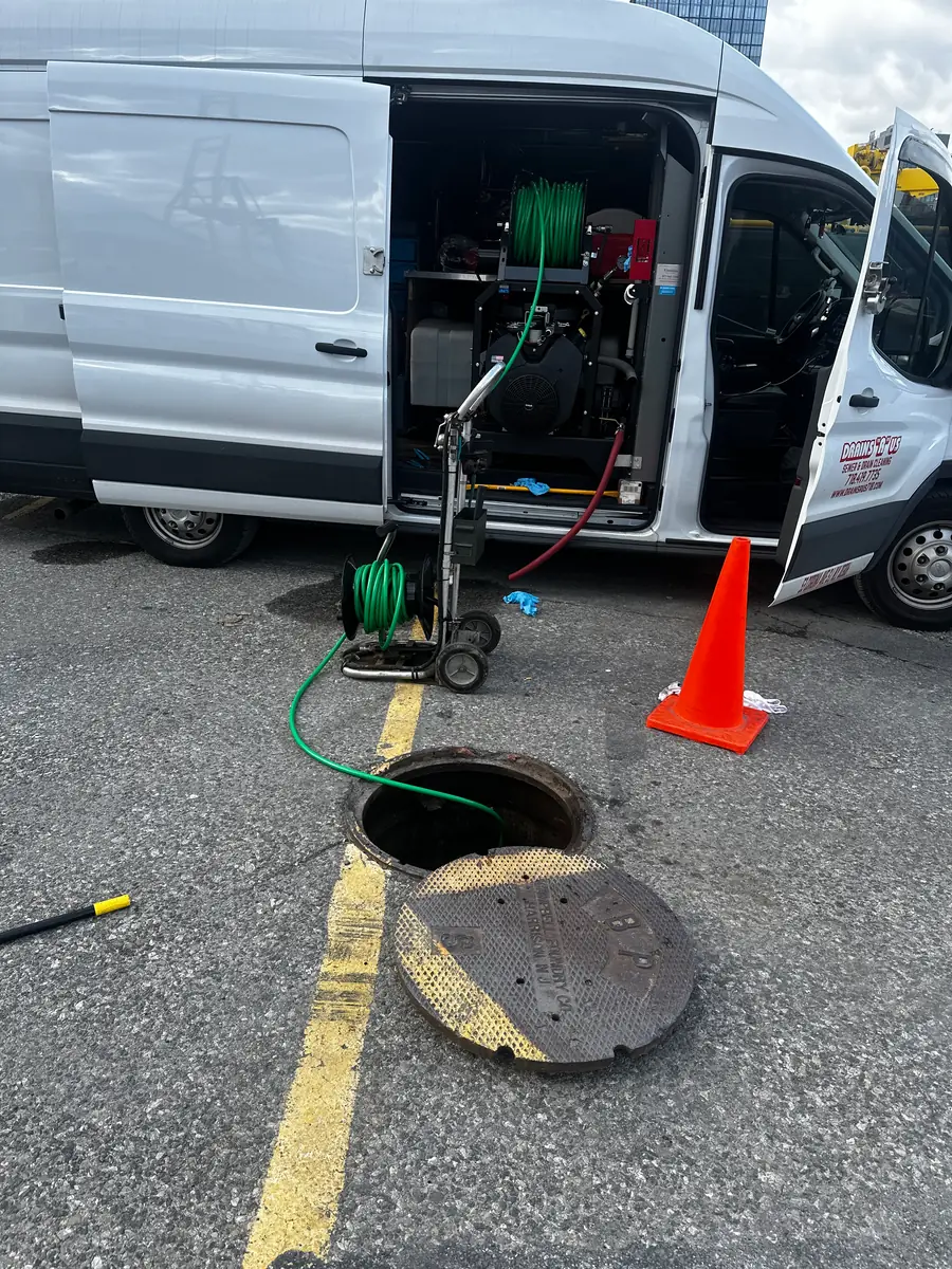 Drains R Us van and jetting equipment set up at an open sewer manhole