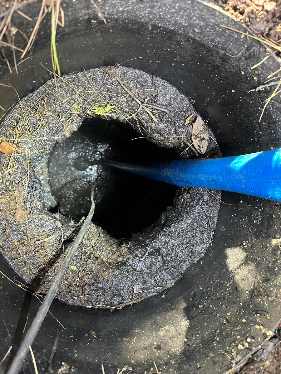 High pressure jetter clearing a blocked sewer manhole