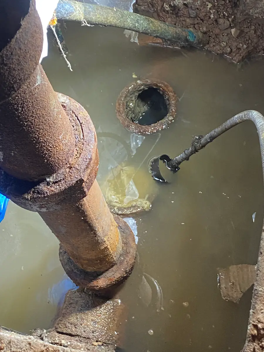 Sewer pipe surrounded by standing water during a repair